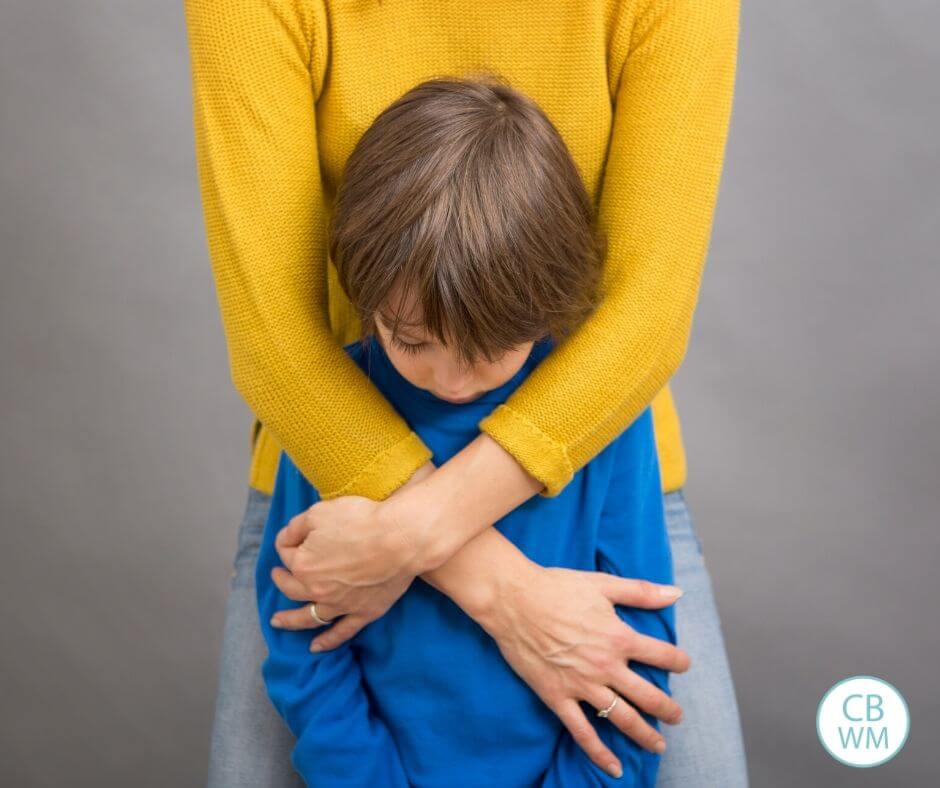 Mother putting arms around sad child