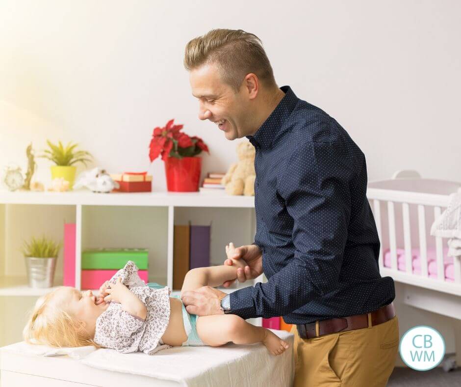 Dad changing toddler's diaper