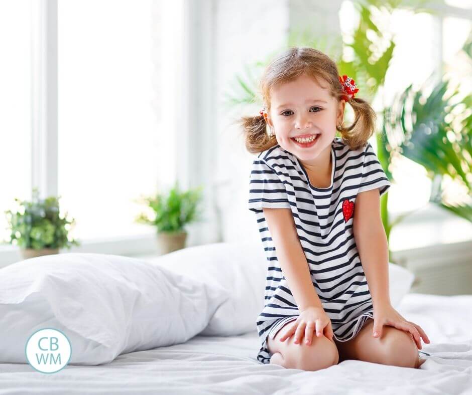 Happy child sitting on the bed