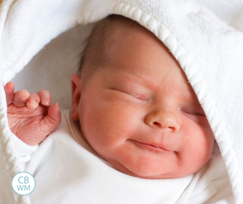 Newborn baby dressed in white sleeping