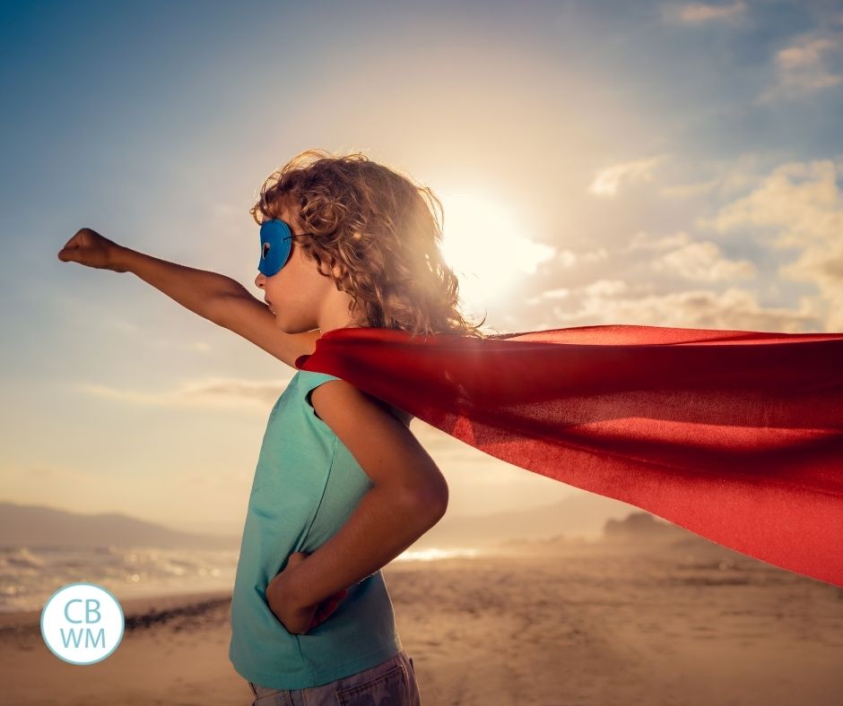 Child wearing a cape on the beach