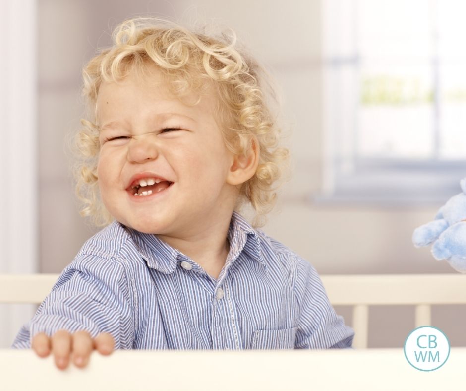 Toddler playing in a crib