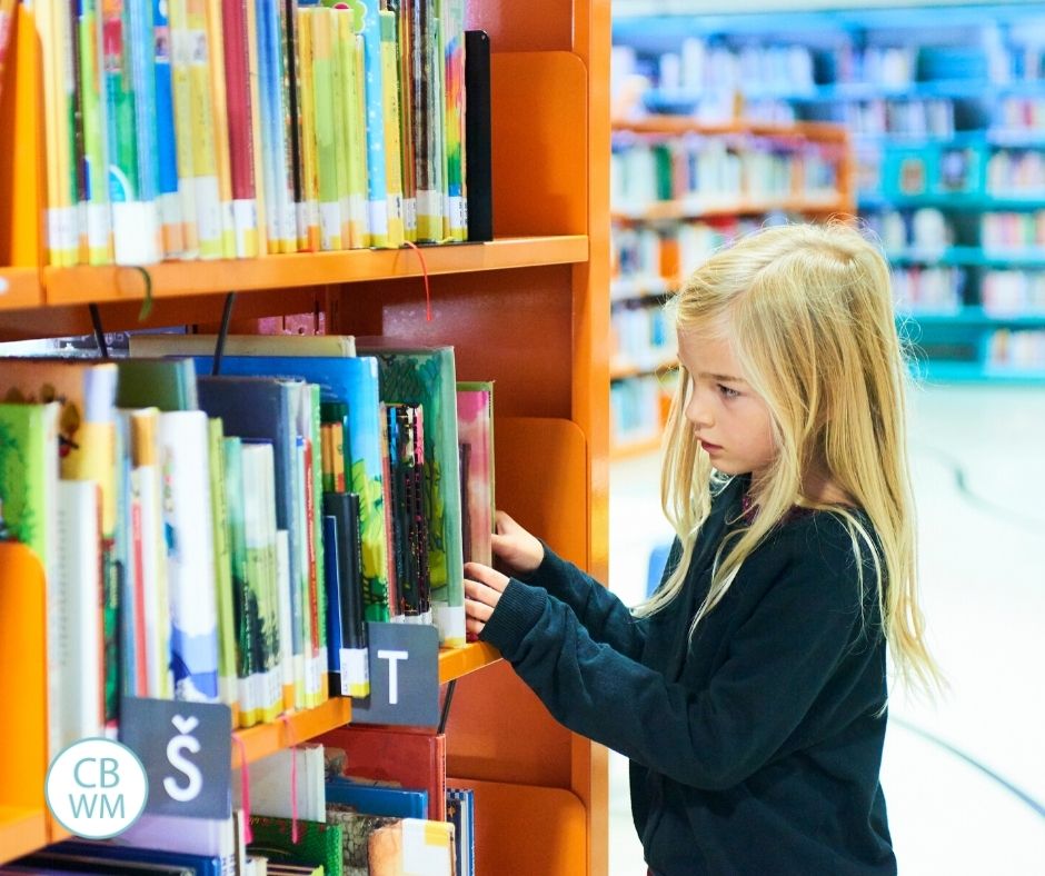 girl looking through books in a library