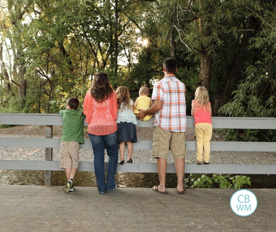 Plowman family looking away from the camera at a small river