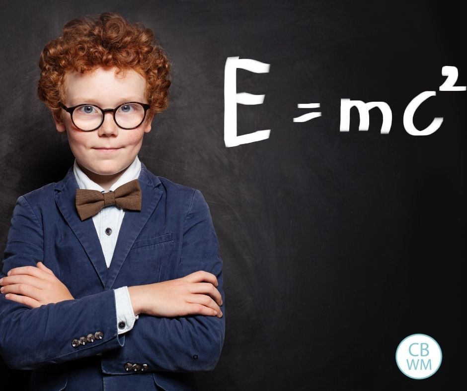 child standing with arms folded and e=mc squared on the chalkboard
