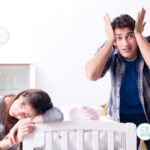 frustrated parents by baby's crib