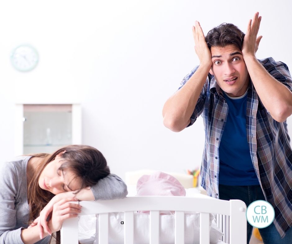 frustrated parents by baby's crib