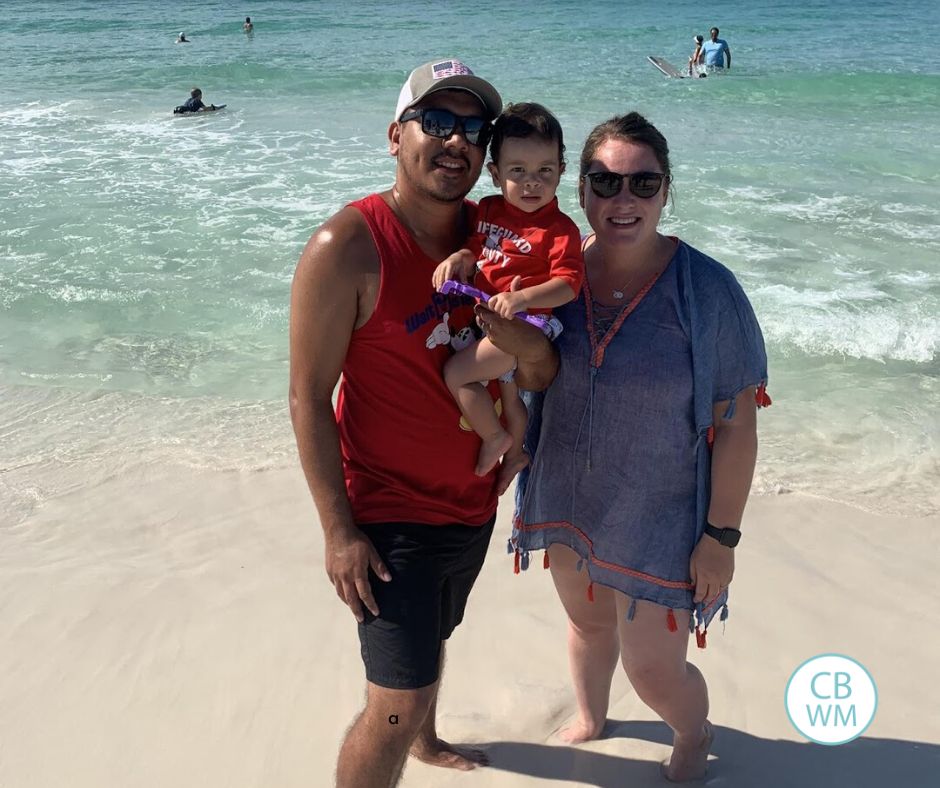 Toddler at beach with parents