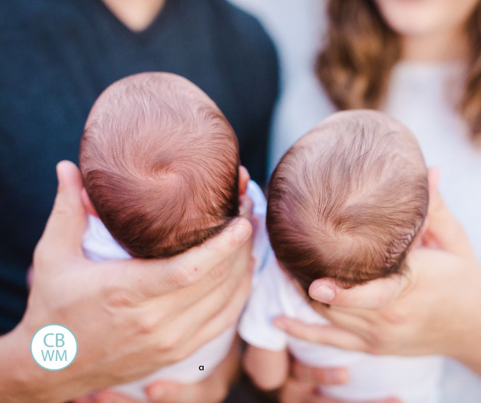 Twin babies being held by their parents