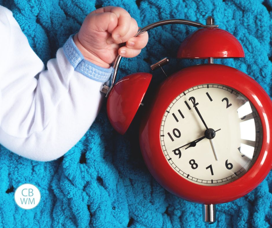Baby holding on to a clock