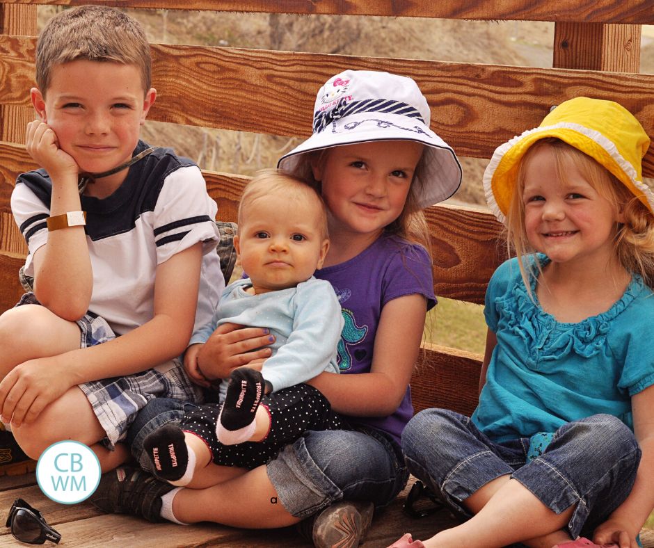 4 kids sitting on a bridge