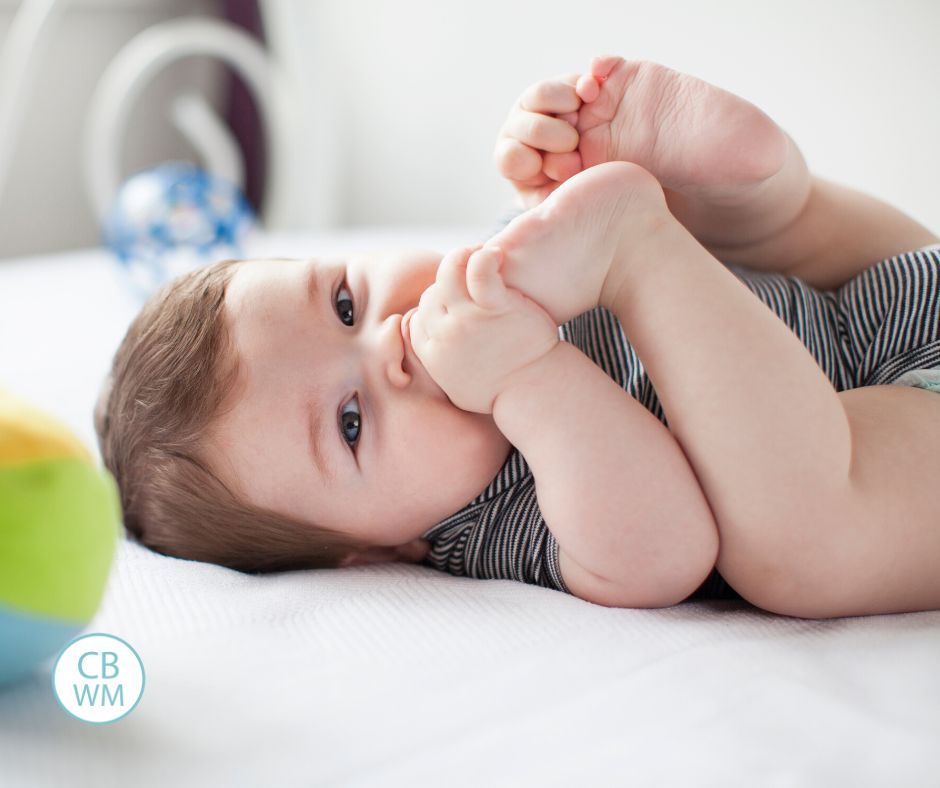 Happy baby sucking on toes