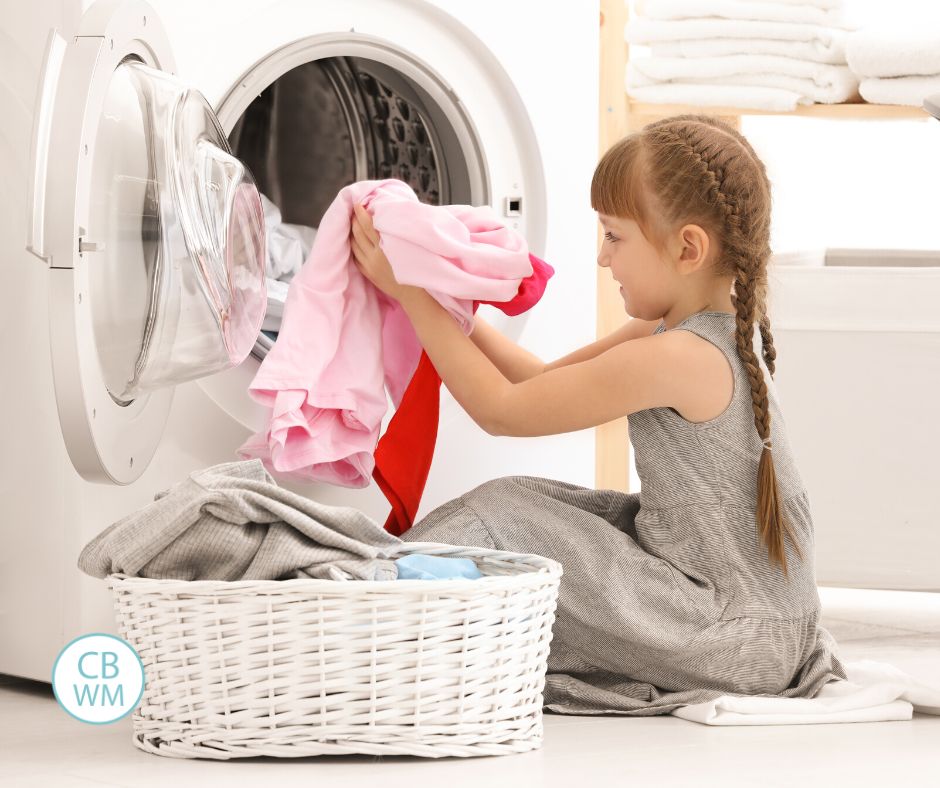 Child pulling laundry from the dryer