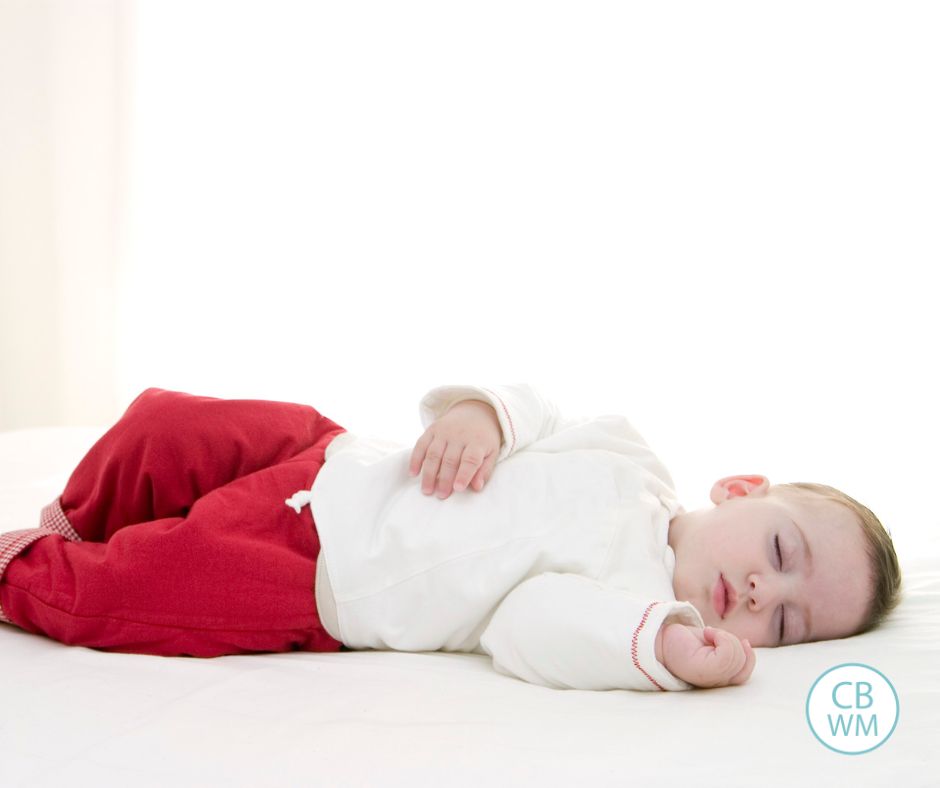 Baby napping with red pants and a white shirt