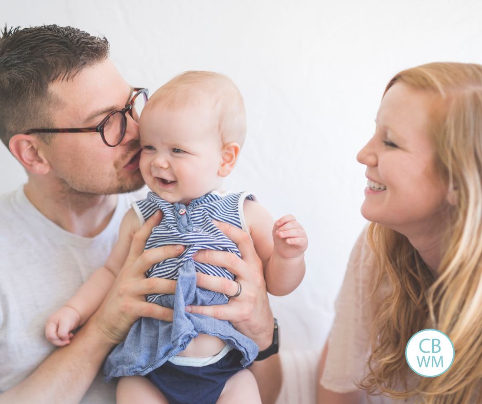 Dad kissing baby's cheek while mom watches