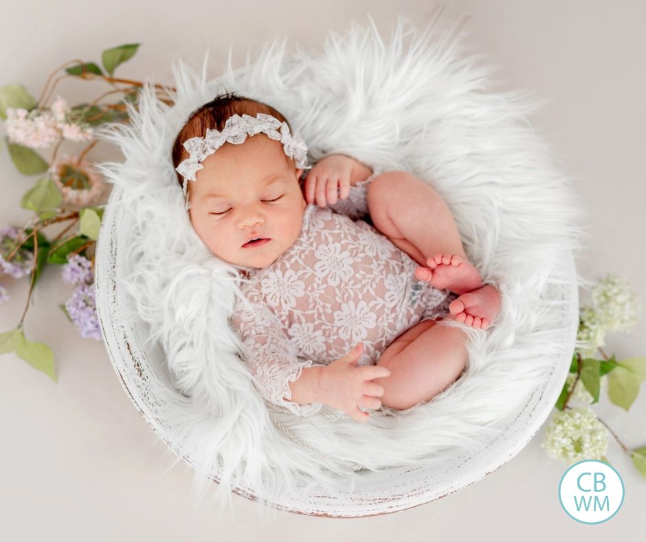 Baby sleeping in a basket on a fur blanket