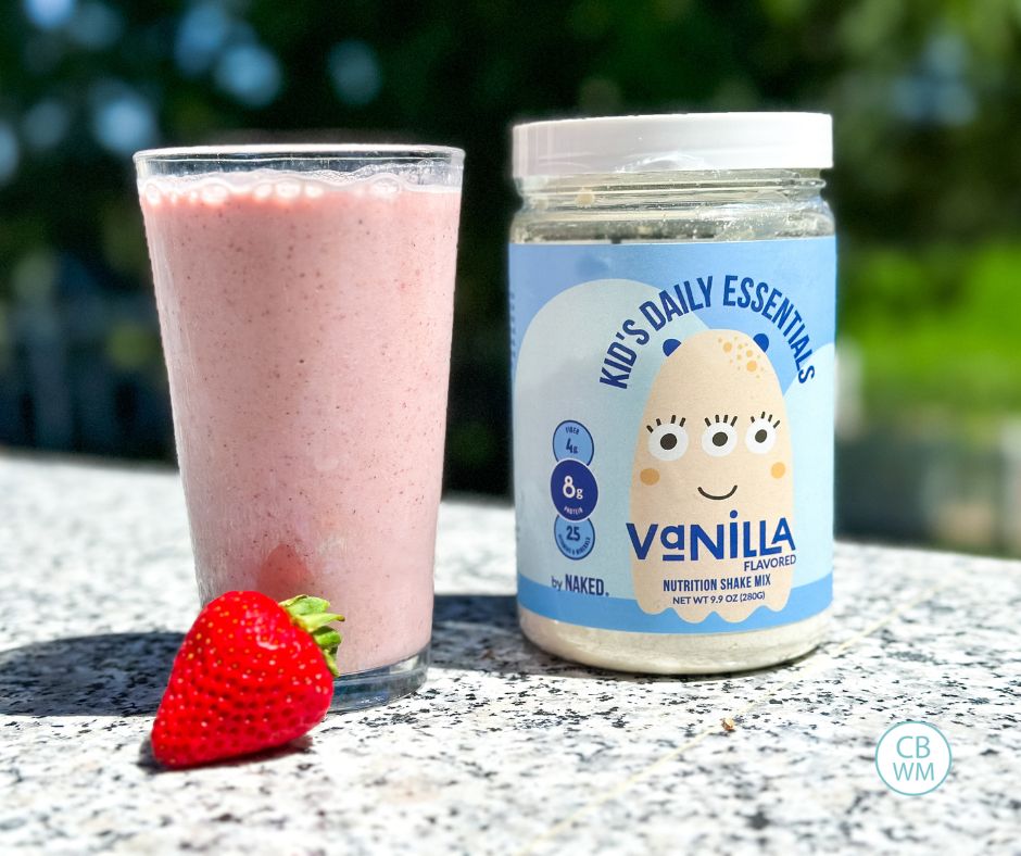 Naked Nutrition container next to a strawberry smoothie