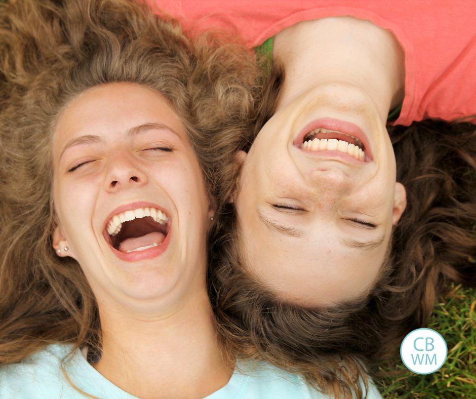 Teens laying on the grass laughing