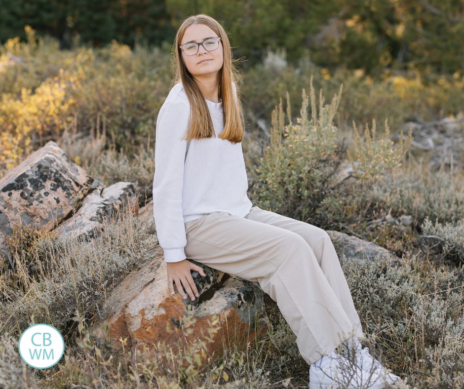 Brinley sitting on a rock in the mountains