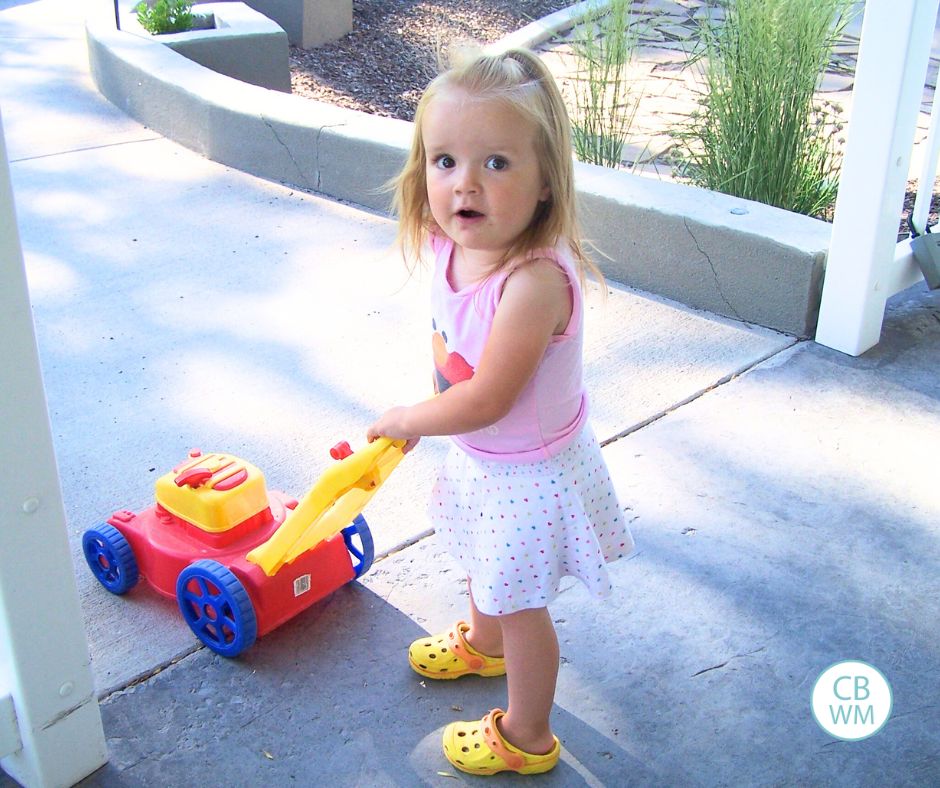 Kaitlyn pushing a toy lawnmower