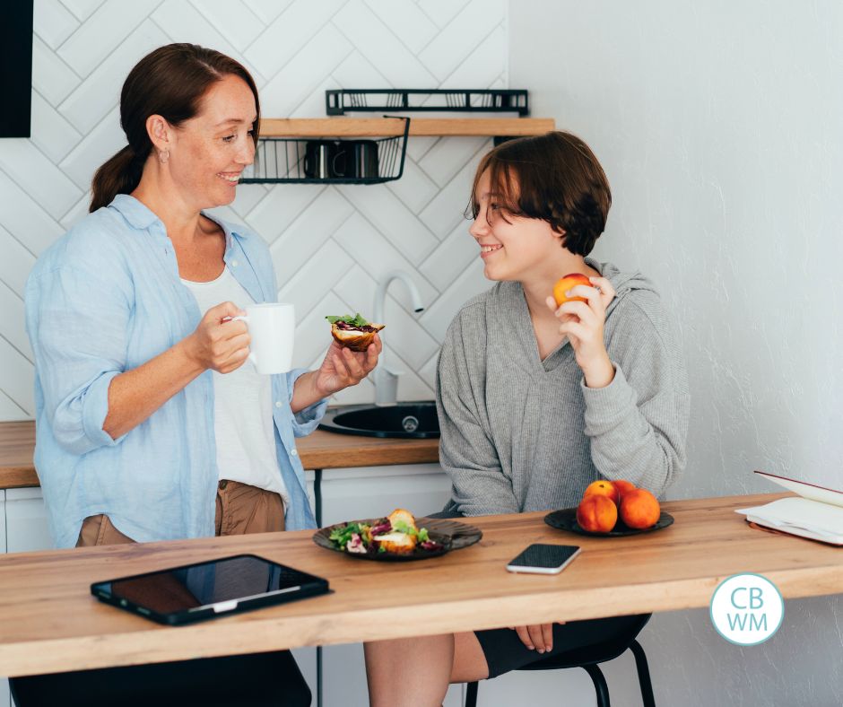 Mom talking to her teen while they eat snacks