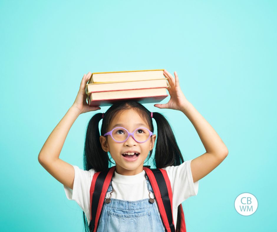 Girl with a backpack on and books on her head