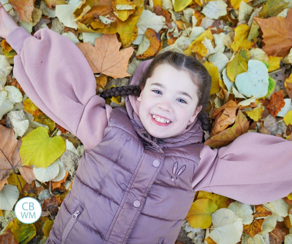 Child laying in leaves