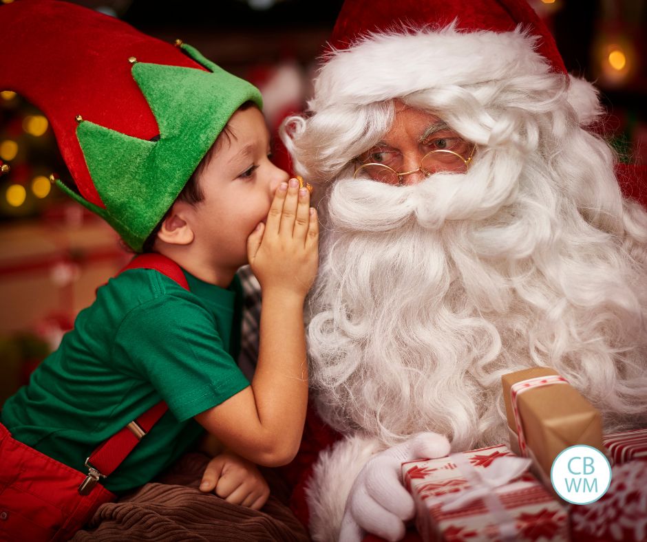 child whispering in Santa's ear