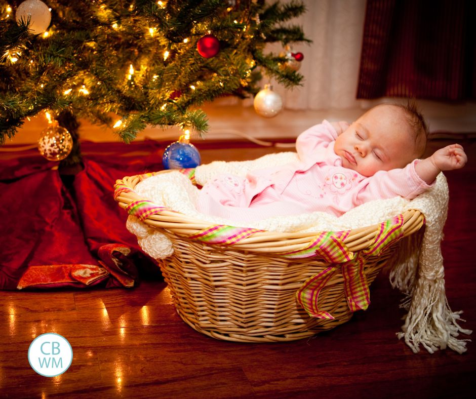 Baby sleeping under a Christmas tree