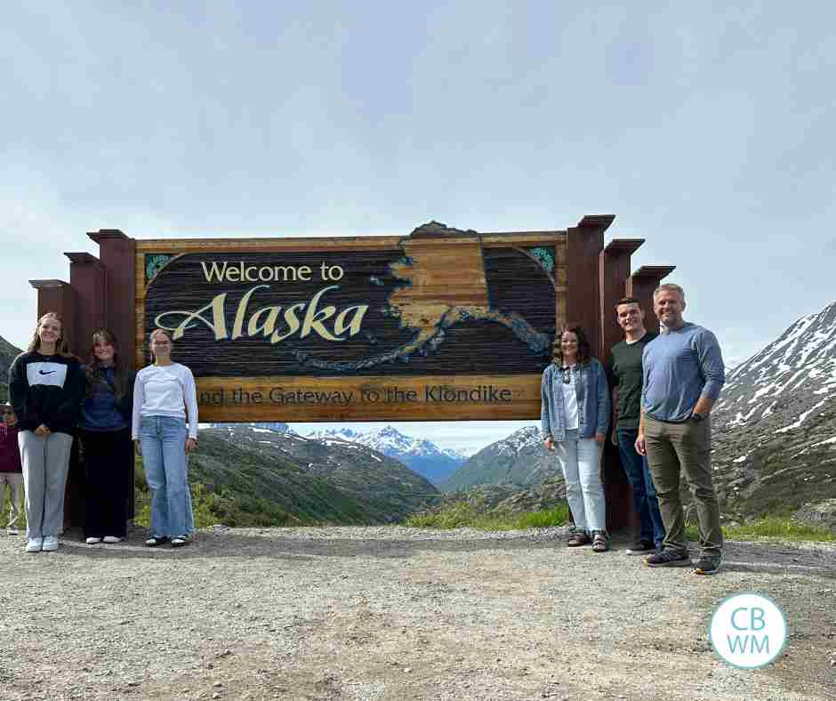 Welcome to Alaska sign with our family surrounding it