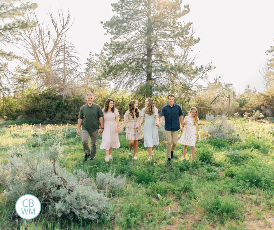 Our family walking through a green field with yellow flowers