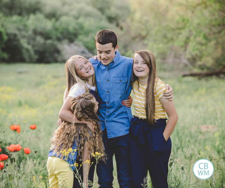 Our kids standing in a green field laughing together