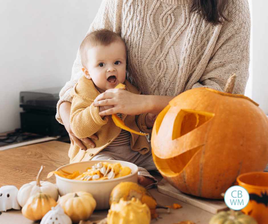 Baby trying to eat pumpkin