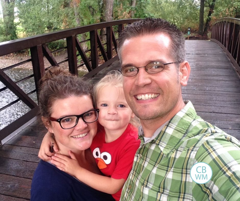 Valerie, Nate, and 3 year old Brinley outside on a bridge
