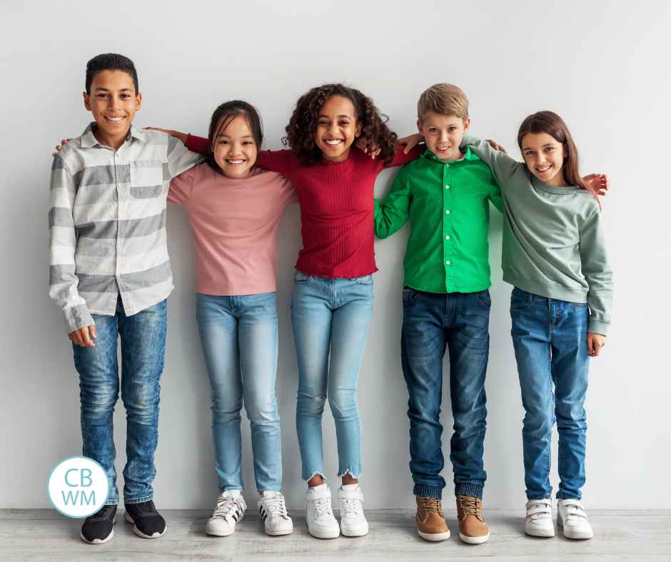 Group of preteens standing by each other in a line with arms around each other