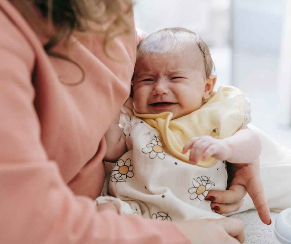 Baby crying in her moms arms