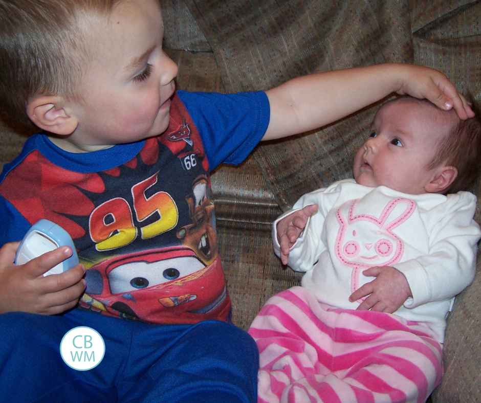 Brayden sitting with newborn Kaitlyn